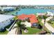 Stunning waterfront home with a red tile roof, lush landscaping, and panoramic water views at 320 Bath Club Blvd S, North Redington Beach, FL 33708