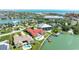 An aerial view shows waterfront homes, each with distinct architectural styles and private docks extending into the serene water at 320 Bath Club Blvd S, North Redington Beach, FL 33708