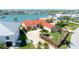Beautiful exterior showcasing a home's manicured lawn, lush landscaping, and circular driveway leading to its charming entrance at 320 Bath Club Blvd S, North Redington Beach, FL 33708