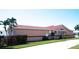 Side exterior view of a single-story home with a red tile roof and green lawn at 320 Bath Club Blvd S, North Redington Beach, FL 33708