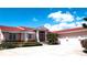 Charming home featuring a red tile roof, two-car garage, and manicured landscaping at 320 Bath Club Blvd S, North Redington Beach, FL 33708