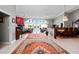 Spacious living room with white tile flooring, chandelier, and views of the water at 320 Bath Club Blvd S, North Redington Beach, FL 33708