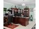 This office features a large desk with a tiled floor, built-in bookshelves, a decorative chandelier and plenty of workspace at 320 Bath Club Blvd S, North Redington Beach, FL 33708