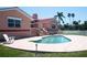 Inviting pool area with brick pavers, lush landscaping, and charming architecture at 320 Bath Club Blvd S, North Redington Beach, FL 33708