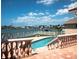 Waterfront pool overlooking beautiful canal, with patio and railings on a sunny day at 320 Bath Club Blvd S, North Redington Beach, FL 33708
