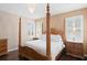 Luxurious main bedroom features a four-poster bed, hardwood floors, and a large window with plantation shutters at 3321 Mapleridge Dr, Lutz, FL 33558