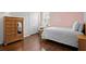 Cozy bedroom showcasing hardwood floors, a dresser with mirror, and a comfortable bed at 3321 Mapleridge Dr, Lutz, FL 33558