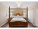 Luxurious main bedroom features a four-poster bed, hardwood floors, and a large window with plantation shutters at 3321 Mapleridge Dr, Lutz, FL 33558