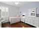 Cozy bedroom featuring a full bed, white furniture, and a window with plantation shutters at 3321 Mapleridge Dr, Lutz, FL 33558