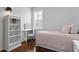 Bright bedroom with hardwood floors featuring a white bookcase, bed, and window with shutters at 3321 Mapleridge Dr, Lutz, FL 33558