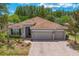 Beautiful single-story home with a three-car garage, brick driveway, and manicured landscaping at 3321 Mapleridge Dr, Lutz, FL 33558