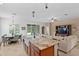 Open-concept kitchen featuring granite countertops, stainless steel appliances, and island seating with an adjacent living room at 3321 Mapleridge Dr, Lutz, FL 33558