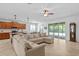 Spacious living room with tile flooring, large sectional sofa, and sliding glass doors to the lanai at 3321 Mapleridge Dr, Lutz, FL 33558