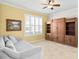 Comfortable living room features a cozy couch, large window with shutters, and a spacious built-in bookcase at 3321 Mapleridge Dr, Lutz, FL 33558