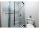 Modern bathroom featuring a glass door shower with blue tile accent and a toilet on the right at 3540 42Nd S St # F, St Petersburg, FL 33711