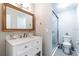 Bathroom featuring a single sink vanity, framed mirror, and glass enclosed shower with a toilet on the right at 3540 42Nd S St # F, St Petersburg, FL 33711