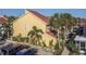 A beautiful yellow townhome showcases well-maintained landscaping with palm trees and plenty of parking at 3540 42Nd S St # F, St Petersburg, FL 33711