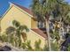 Charming yellow condo exterior featuring lush tropical landscaping and modern architectural details at 3540 42Nd S St # F, St Petersburg, FL 33711