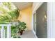 Comfortable outdoor patio with sliding glass door, tropical plants and white railings at 3540 42Nd S St # F, St Petersburg, FL 33711