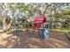 Community playground featuring a swing set and play structure, surrounded by mature trees and shaded areas at 3540 42Nd S St # F, St Petersburg, FL 33711