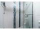 Bathroom shower featuring white tile, a glass door, and stylish vertical green tile accents at 3540 42Nd S St # F, St Petersburg, FL 33711