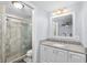 Bathroom featuring tiled shower, granite countertop, and contemporary lighting at 3614 S Lois Ave, Tampa, FL 33629