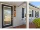 Beautiful front entryway featuring a black trimmed glass door, grey siding, and brick porch at 3614 S Lois Ave, Tampa, FL 33629