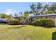 Well-maintained home with a green front lawn, manicured hedges, and brick walkway at 3614 S Lois Ave, Tampa, FL 33629