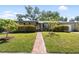 Charming single-story home with well-manicured lawn, walkway, and mature trees on a sunny day at 3614 S Lois Ave, Tampa, FL 33629