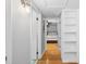 Hallway view into the bedroom featuring wood floors and white shelving at 3614 S Lois Ave, Tampa, FL 33629