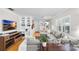 Bright living room with a large gray couch, decorative shelving, and hardwood floors at 3614 S Lois Ave, Tampa, FL 33629