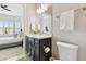 Bathroom with single vanity and commode; bedroom with plantation shutters is visible through doorway at 5858 Shorebird Br, Land O Lakes, FL 34638