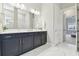 Elegant bathroom with double vanity, marble floors and an adjoining doorway at 5858 Shorebird Br, Land O Lakes, FL 34638