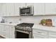Modern kitchen featuring stainless steel appliances, a gas cooktop, and sleek white cabinetry at 5858 Shorebird Br, Land O Lakes, FL 34638