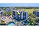 Stunning aerial view of a high-rise condo building with a pool, lush landscaping, and a golf course nearby at 6 Belleview Blvd # 505, Belleair, FL 33756