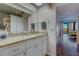 Bathroom with granite countertops, white cabinets, and hallway view at 6 Belleview Blvd # 505, Belleair, FL 33756