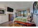 Cozy bedroom featuring hardwood floors, balcony access, and tropical leaf patterned bedding at 6 Belleview Blvd # 505, Belleair, FL 33756