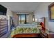 Bright bedroom with hardwood floors, balcony access, and large mirror reflecting water views at 6 Belleview Blvd # 505, Belleair, FL 33756