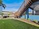 Beautiful backyard featuring a wooden staircase, lush green lawn, and waterfront access for serene outdoor living at 6241 Bayside Dr, New Port Richey, FL 34652
