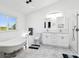 All-white bathroom features a soaking tub, double vanity, and walk-in shower at 6241 Bayside Dr, New Port Richey, FL 34652