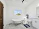 Bright bathroom with clawfoot tub, marble floor, and a view of the outdoors at 6241 Bayside Dr, New Port Richey, FL 34652