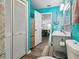 Charming bathroom with turquoise walls, a single vanity, nautical décor, and stylish wood-look flooring at 6241 Bayside Dr, New Port Richey, FL 34652