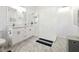 Modern bathroom with double vanity, glass-enclosed shower, white marble-style tiling, and sleek fixtures at 6241 Bayside Dr, New Port Richey, FL 34652