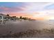 Scenic beach view featuring pristine sand, palm trees, and covered picnic areas at sunset at 6241 Bayside Dr, New Port Richey, FL 34652