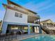 Multi-story home featuring a covered patio, balcony, and pool, ideal for outdoor entertaining and relaxation at 6241 Bayside Dr, New Port Richey, FL 34652
