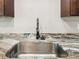Close-up of a stainless steel kitchen sink with a modern faucet and granite countertop at 6241 Bayside Dr, New Port Richey, FL 34652