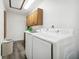 Laundry room with white washer and dryer, wood cabinets and vinyl floors at 6241 Bayside Dr, New Port Richey, FL 34652
