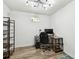 Functional office with a modern desk, rolling chair, shelving, and wood-look flooring for a productive workspace at 6241 Bayside Dr, New Port Richey, FL 34652