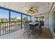 Screened in outdoor dining area with a ceiling fan and views of the water and neighborhood at 6241 Bayside Dr, New Port Richey, FL 34652