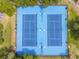 Aerial view of community tennis courts showing the well-maintained blue surface, lighting, and surrounding greenery at 6241 Bayside Dr, New Port Richey, FL 34652
